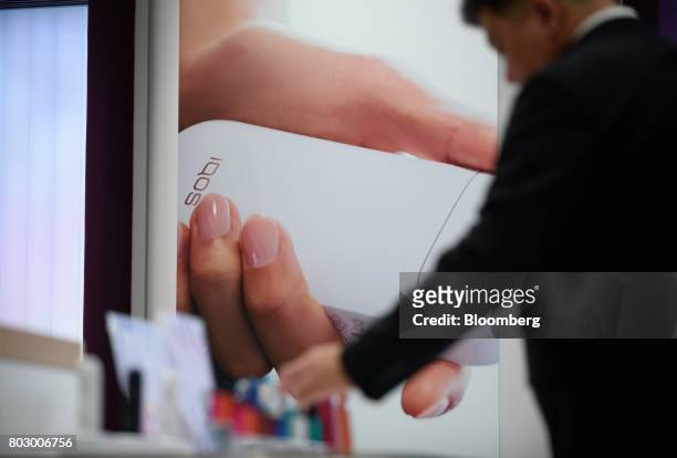 An advertisement for Philip Morris International Inc.'s IQOS smokeless tobacco devices is displayed at IQOS Store Ginza in Tokyo, Japan, on Monday,...