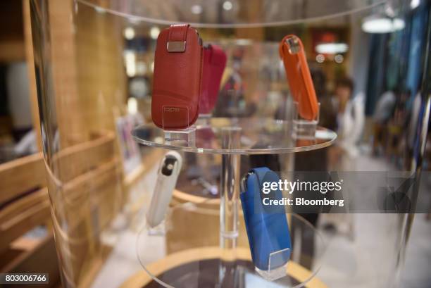 Cases for Philip Morris International Inc.'s IQOS smokeless tobacco devices are displayed at IQOS Store Ginza in Tokyo, Japan, on Monday, June 26,...