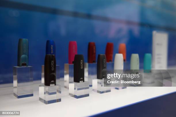 Caps for Philip Morris International Inc.'s IQOS smokeless tobacco devices are displayed at IQOS Store Ginza in Tokyo, Japan, on Monday, June 26,...