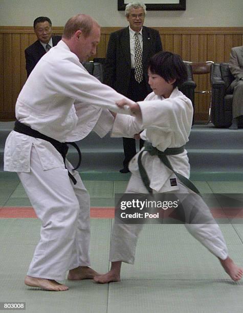 Russian President Vladimir Putin in judo gear struggles against 10-year-old Japanese schoolgirl Natsumi Gomi on tatami mat as he visits Kodokan judo...