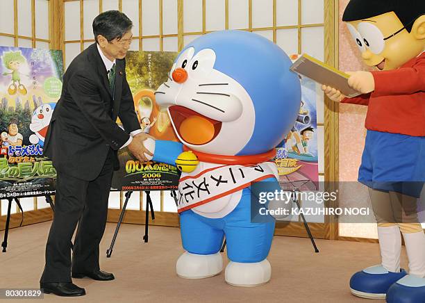 Japan's cartoon character Doraemon , who has been appointed as the nation's first Anime Ambassador, is congratulated by Foreign Minister Masahiko...