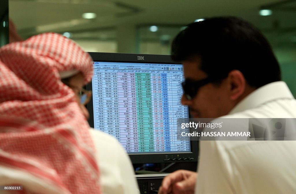 Saudi traders work at a bank in Riyadh o