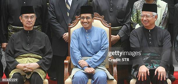 As Malaysian Prime Minister Abdullah Ahmad Badawi looks on, Malaysia's King Mizan Zainal Abidin and Deputy Prime Minister Najib Razak react during a...