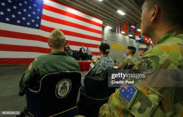 Member of the Australian Army sits in the audience alongside a U.S. Flag as the backdrop of a ceremony marking the start of Talisman Saber 2017, a...