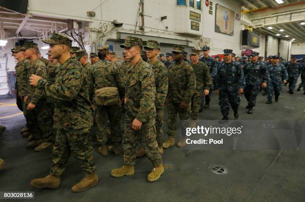 Marines and Navy personnel walk aboard the USS Bonhomme Richard amphibious assault ship during a ceremony marking the start of Talisman Saber 2017, a...