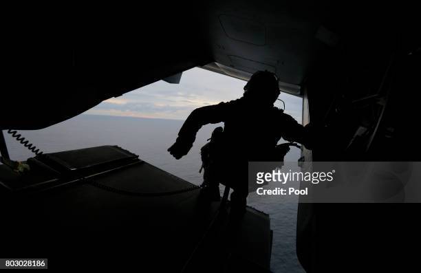 Crewman aboard a U.S. Marine MV-22B Osprey Aircraft looks out over the Pacific Ocean before landing on the deck of the USS Bonhomme Richard...