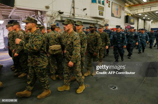 Marines and Navy personnel walk aboard the USS Bonhomme Richard amphibious assault ship during a ceremony marking the start of Talisman Saber 2017, a...