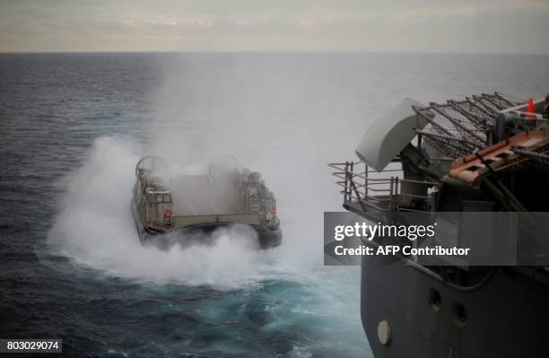 Navy Landing Craft Air Cushion appears from the stern of the USS Bonhomme Richard amphibious assault ship during events marking the start of Talisman...