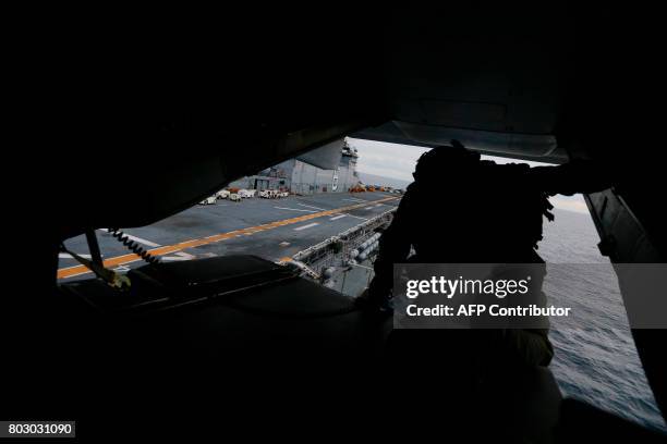 Crewman aboard a US Marine MV-22B Osprey Aircraft looks out over the deck of the USS Bonhomme Richard amphibious assault ship off the coast of Sydney...