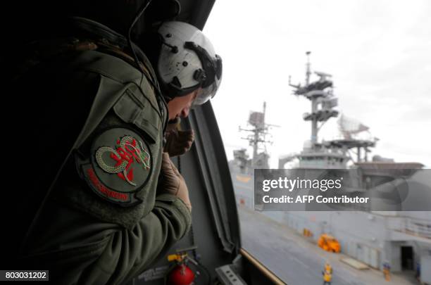 Crewman aboard a US Marine MV-22B Osprey Aircraft looks out over the deck of the USS Bonhomme Richard amphibious assault ship off the coast of Sydney...