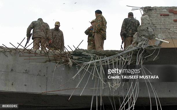 Indian police inspect the top of a damaged flyover after a blast in Srinagar on March 18, 2008. Suspected Islamic militants detonated a bomb on a...