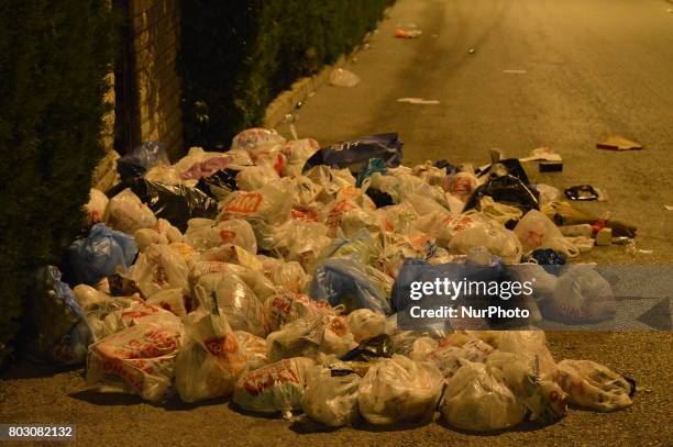 Rubbish piles are seen on the road beside a garbage container at night in Ankara, Turkey on June 29, 2017. Local residents leave their garbage...