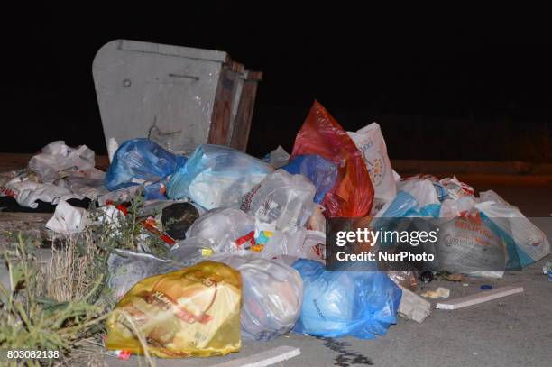 Rubbish piles are seen on the road beside a garbage container at night in Ankara, Turkey on June 29, 2017. Local residents leave their garbage...