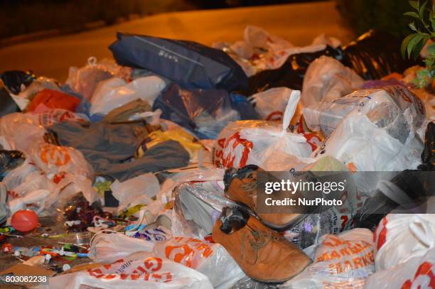 Rubbish piles are seen on the road beside a garbage container at night in Ankara, Turkey on June 29, 2017. Local residents leave their garbage...