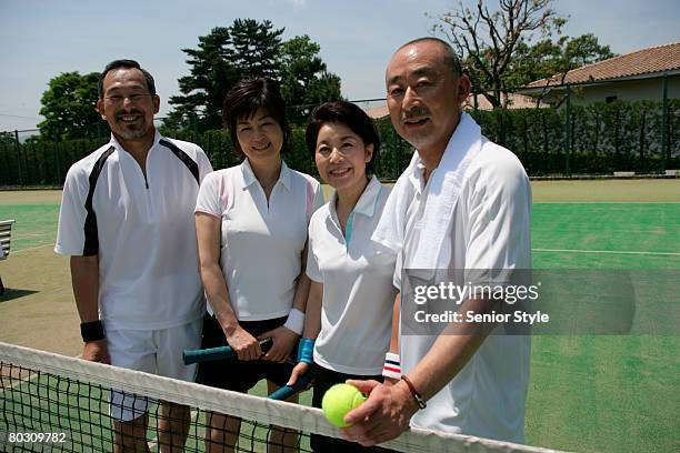 two mature couples relaxing in tennis court, close-up - tennis raquet close up photos et images de collection