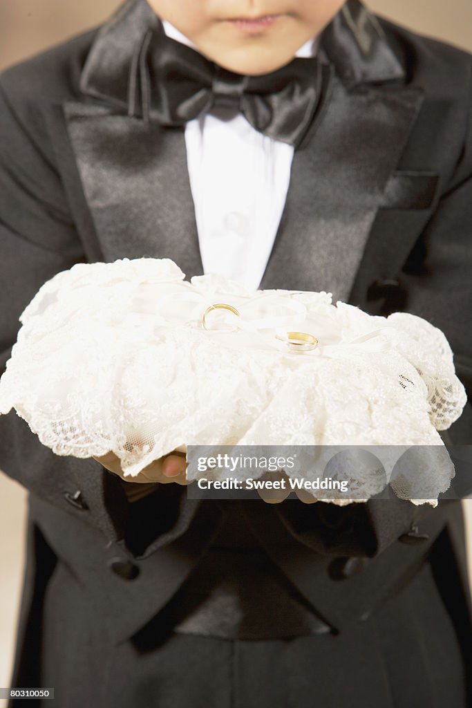 Pageboy holding rings, close-up