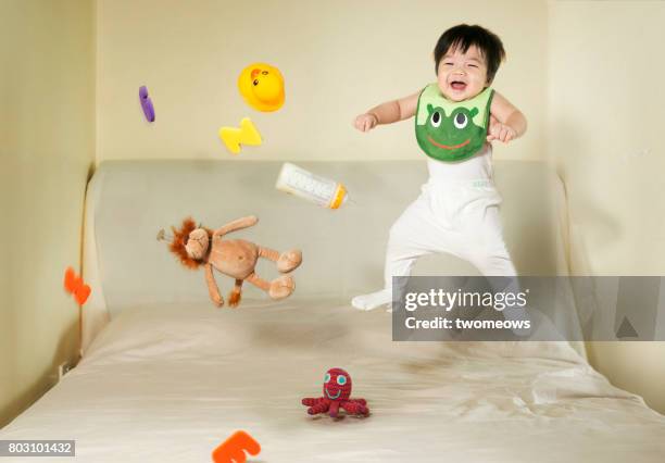 baby boy and toys jumping on bed. - tossing baby in air stock pictures, royalty-free photos & images