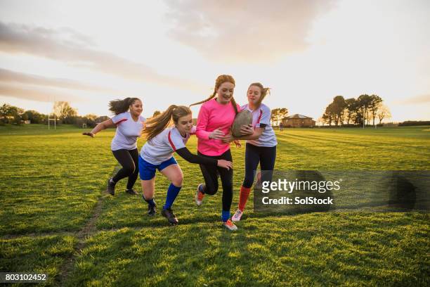 teen girls playing a game of rugby - rugby sport stock pictures, royalty-free photos & images