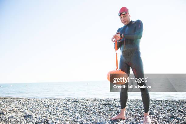 man posing on beach in diving suit - neoprenanzug stock-fotos und bilder