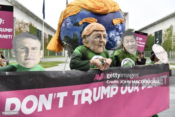 Activists wearing masks of French President Emmanuel Macron, German Chancellor Angela Merkel, China's President Xi Jinping and President of the...