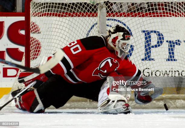 Martin Brodeur of the New Jersey Devils saves a goal after the puck deflects off defenseman Colin White in a game against the New York Rangers on...