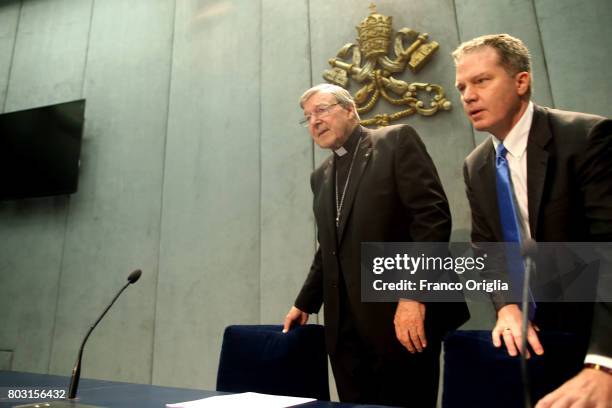 Australian Cardinal George Pell, flanked by Vatican spokesman Greg Burke , arrives at the Holy See Press Room for a press conference on June 29, 2017...