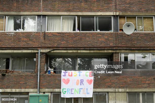 Banner reading "Justice for Grenfell" hangs from a block of flats on the day of the funeral of one of the victims of the fire in Grenfell Tower, on...