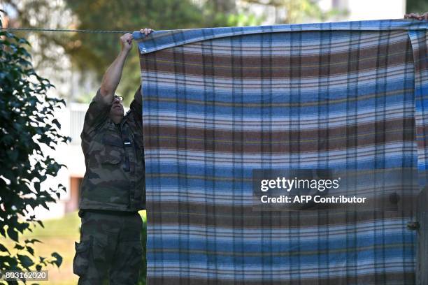 French gendarme hangs a blanket outside the gendarmerie to hide Murielle Bolle on June 29, 2017 in Saint-Etienne-Les-Remiremont, eastern France,...