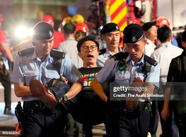 Pro-democracy protesters is removed by police officers from the golden bauhinia statue ahead of the 20th anniversary of Hong Kong's handover to China...