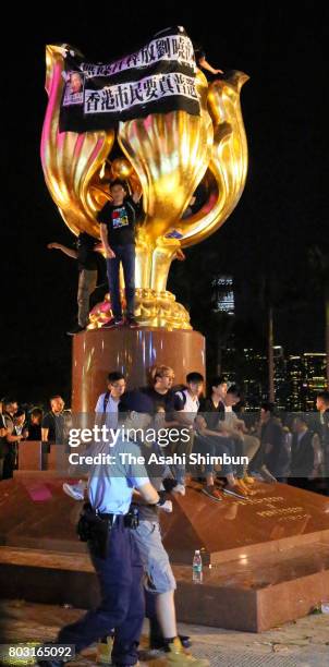 Pro-democracy protesters is removed by police officers from the golden bauhinia statue ahead of the 20th anniversary of Hong Kong's handover to China...