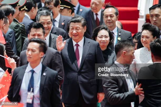 Xi Jinping, China's president, center, waves as he greets attendees with Peng Liyuan, China's first lady, right, Leung Chun-ying, Hong Kong's chief...