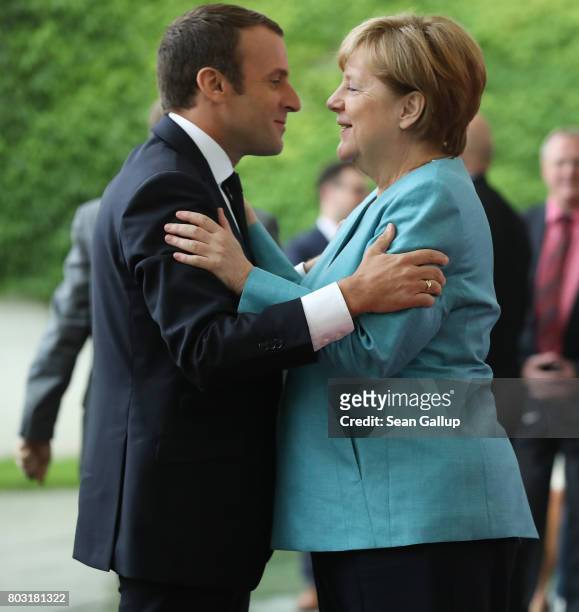 German Chancellor Angela Merkel greets French President Emmanuel Macron prior to a meeting of European Union leaders at the Chancellery on June 29,...