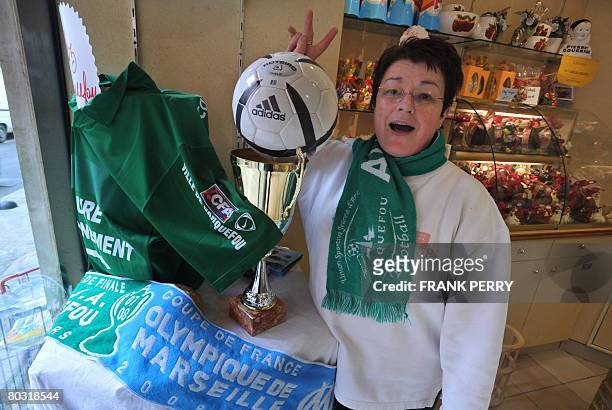 Baker and fan of amateur side football team of Carquefou makes the victory sign, on March 20, 2008 at her backery in Carquefou, a suburb of Nantes,...