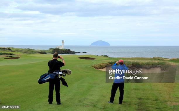Players stop to take pictures view looking down the par 5, eighth hole with the Turnberry Lighthouse and the island of Ailsa Craig in teh distance on...