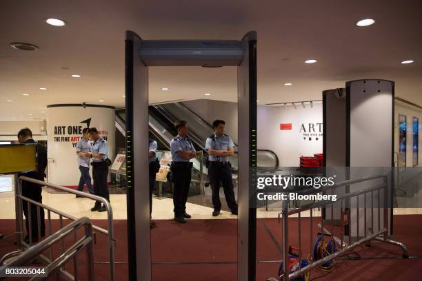 Police officers stand next to metal detectors at the Hong Kong Convention and Exhibition Center, ahead of the 20th anniversary of Hong Kong's...