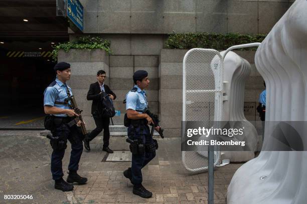 Armed police officers walk past water barricades near the Hong Kong Convention and Exhibition Center, ahead of the 20th anniversary of Hong Kong's...