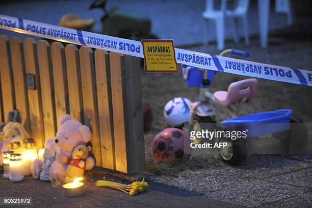 Candles and teddy bears are placed outside the roped-off house in Arboga, Sweden, on March 20, 2008. Two children were stabbed to death and their...