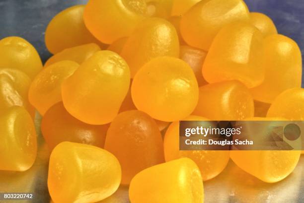 full frame of yellow colored soft chew gummy pills for children - medicare supplement stock pictures, royalty-free photos & images