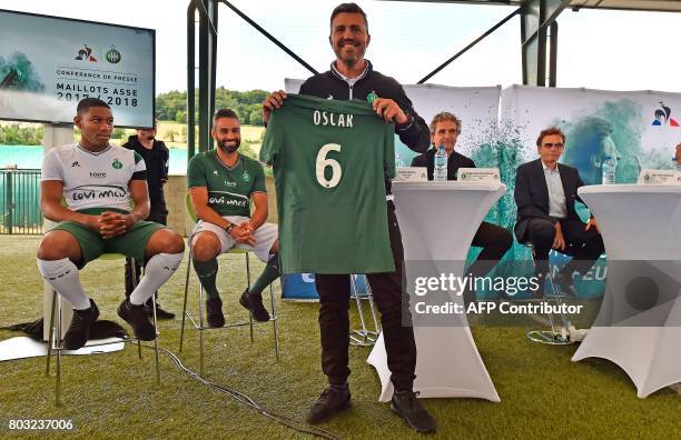 Saint-Etienne's Spanish head coach Oscar Garcia poses with the new jersey of the Ligue 1 football team at a press conference in L'Etrat near...