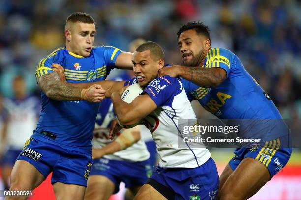 Moses Mbye of the Bulldogs is tackled during the round 17 NRL match between the Parramatta Eels and the Canterbury Bulldogs at ANZ Stadium on June...