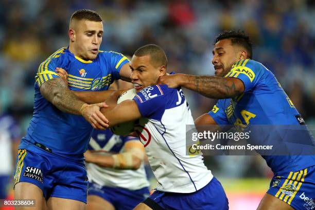 Moses Mbye of the Bulldogs is tackled during the round 17 NRL match between the Parramatta Eels and the Canterbury Bulldogs at ANZ Stadium on June...