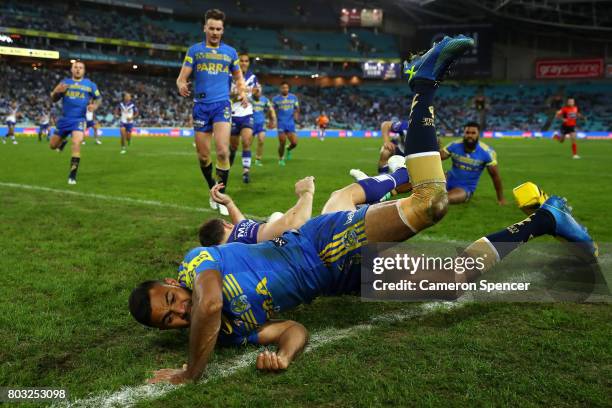 Brett Morris of the Bulldogs scores a try as Bevan French of the Eels attempts to stop him in goal during the round 17 NRL match between the...