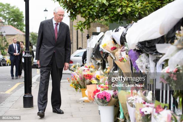 Sir Martin Moore-Bick looks at floral tributes as he leaves the Parish of St Clement church after meeting local residents on June 29, 2017 in London,...