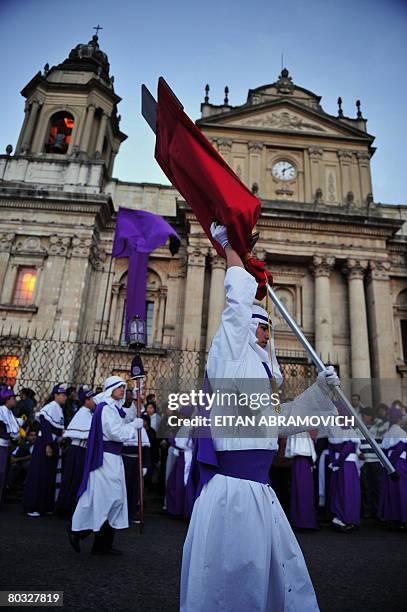 Parishioners march in front of Guatemala's Metropolitan Cathedral as they take part in a Holy Thurdsday procession in the streets of the historical...