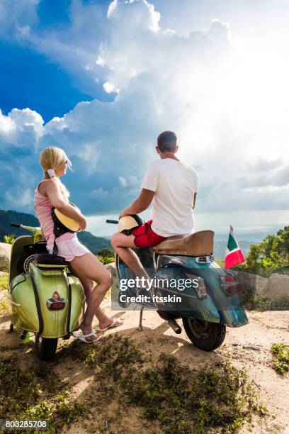 paar auf der sonnigen tropischen strand mit einem grünen retro-bike - roller vintage stock-fotos und bilder