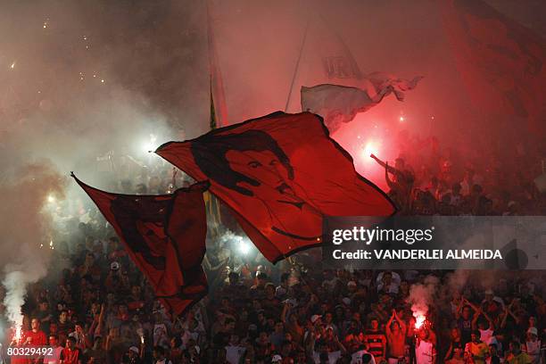 Fans of the Brazilian football team Flamengo wave flags with images of former team players, on March 19 before a Libertadores Cup match against...