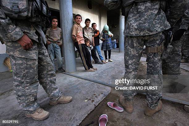 Iraqi children stare at US soldiers from 3rd Squadron 2nd Stryker Cavalry Regiment on patrol in the restive Diyala province, northeast of Baghdad, on...