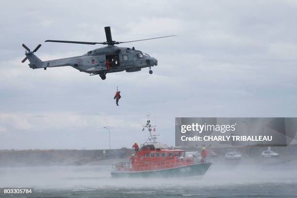 Members of the Societe Nationale de Sauvetage en Mer train with a super hornet helicopter and an unsinkable rescue boat during the National Day of...