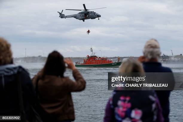 People watch members of the Societe Nationale de Sauvetage en Mer train with a super hornet helicopter and an unsinkable rescue boat during the...