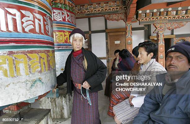 Bhutanese woman rolls the Dharma Chakra as others wait for treatment at a Indigenious Hospital in Thimphu on March 21, 2008. The tiny Himalayan...